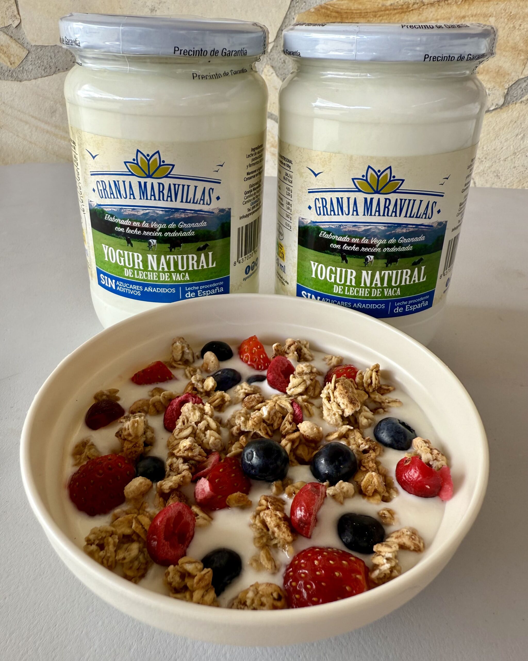 Yogur natural de Granja Maravillas, granola con avena y frutos rojos frescos.